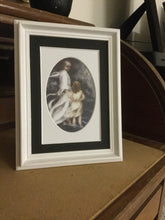 Load image into Gallery viewer, A small white framed version of the black 5 inch by 7 inch black and white oval matted version of the print of Jesus and little child walking on the water together in a bad storm. A matted print illustrated by artist Suzanne Davis Harden. This small frame does not include glass.