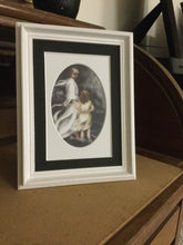 Load image into Gallery viewer, A small white framed version of the black 5 inch by 7 inch black and white oval matted version of the print of Jesus and little child walking on the water together in a bad storm.  A  matted print illustrated by artist Suzanne Davis Harden. This small frame does not include glass.
